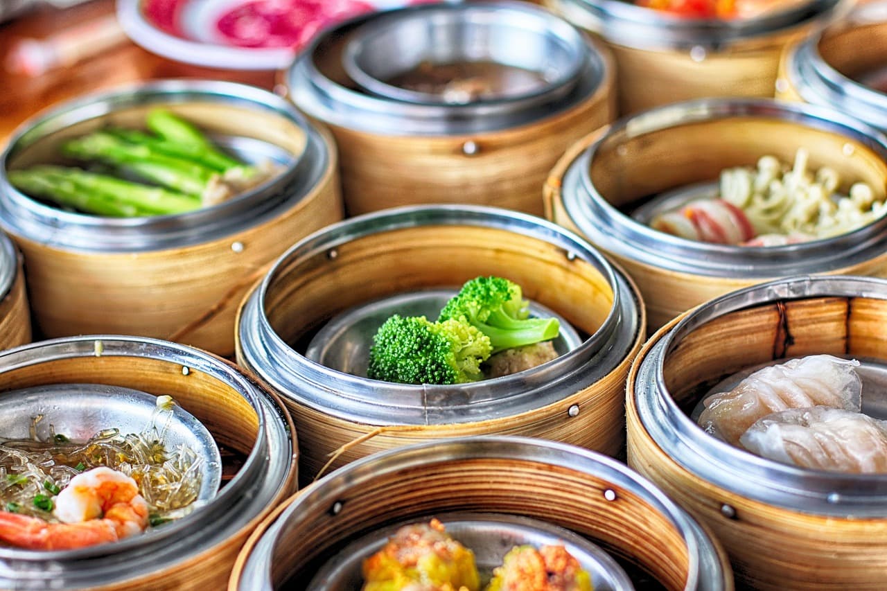 Steaming dim sum baskets and dumplings styled as a Melbourne Asian catering feast.